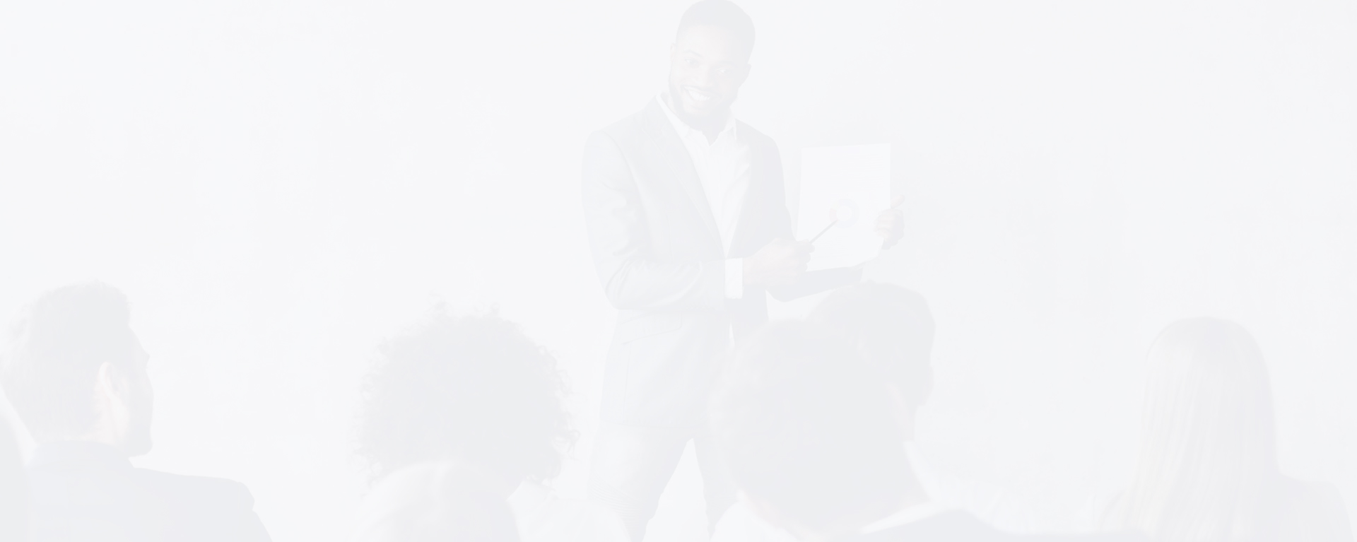Man in a suit presenting a document to an audience during a seminar or workshop.